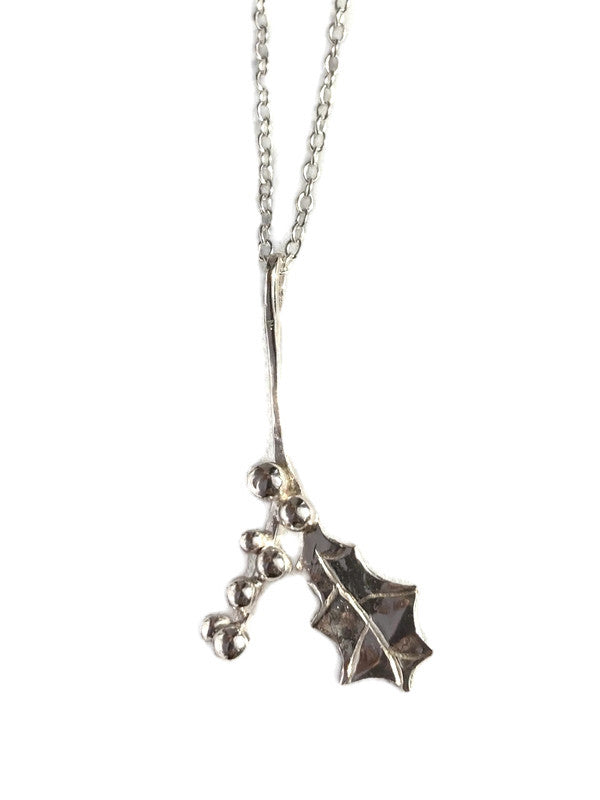 A sterling silver Christmas holly branch pendant necklace by Kim Styles Jewellery, on a delicate chain, shown against a plain white background.