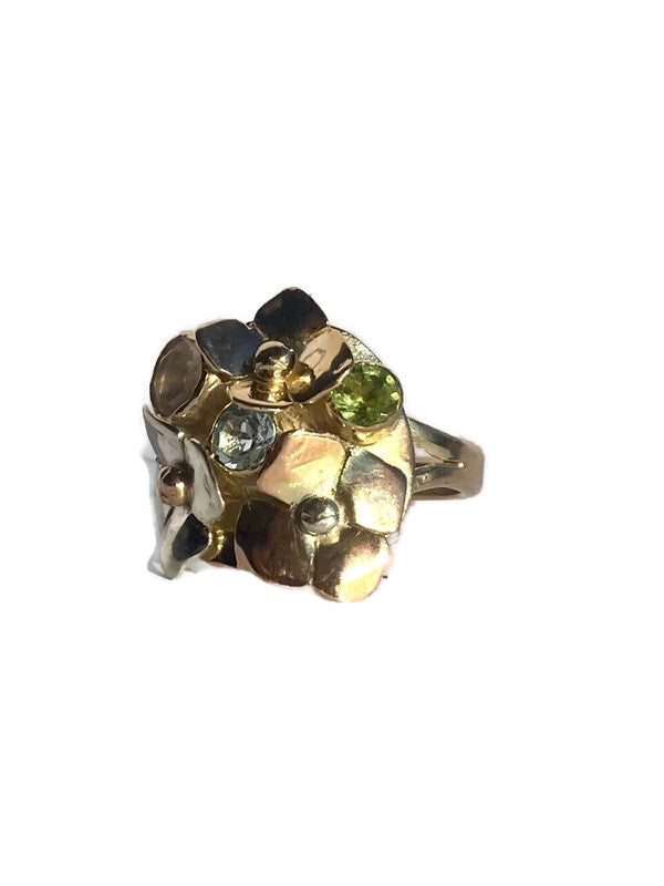 Gold flower cluster cocktail ring with gemstones on a white background