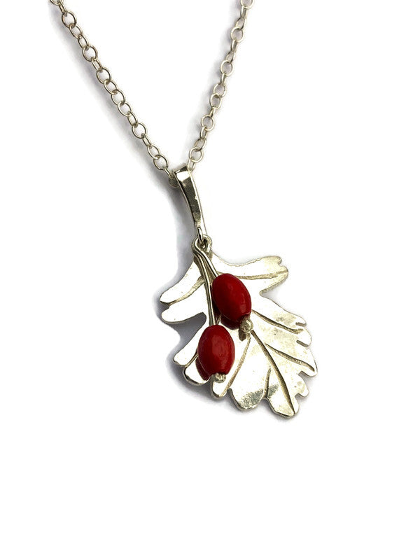 Hand made Hawthorne leaf pendant with hanging red berries on dainty silver chain, on white background