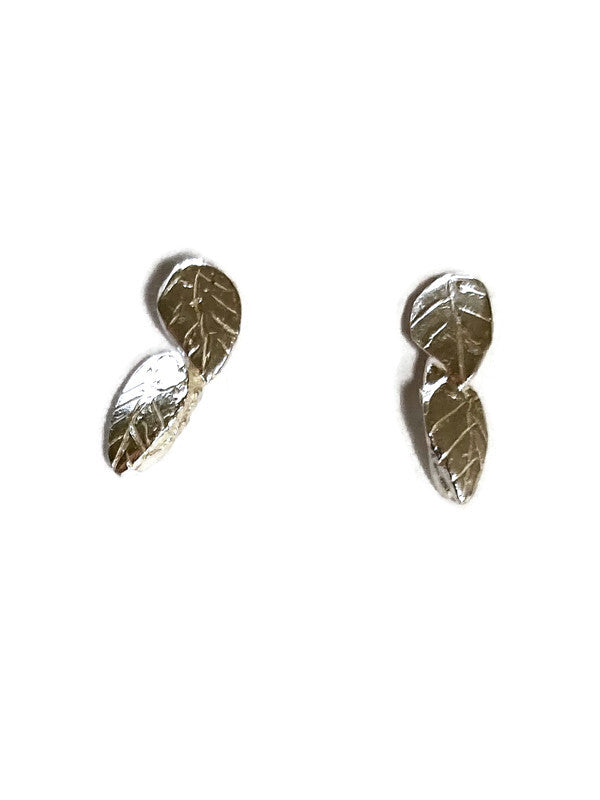 Sterling silver stud earrings in the form of two leaves, on a white background