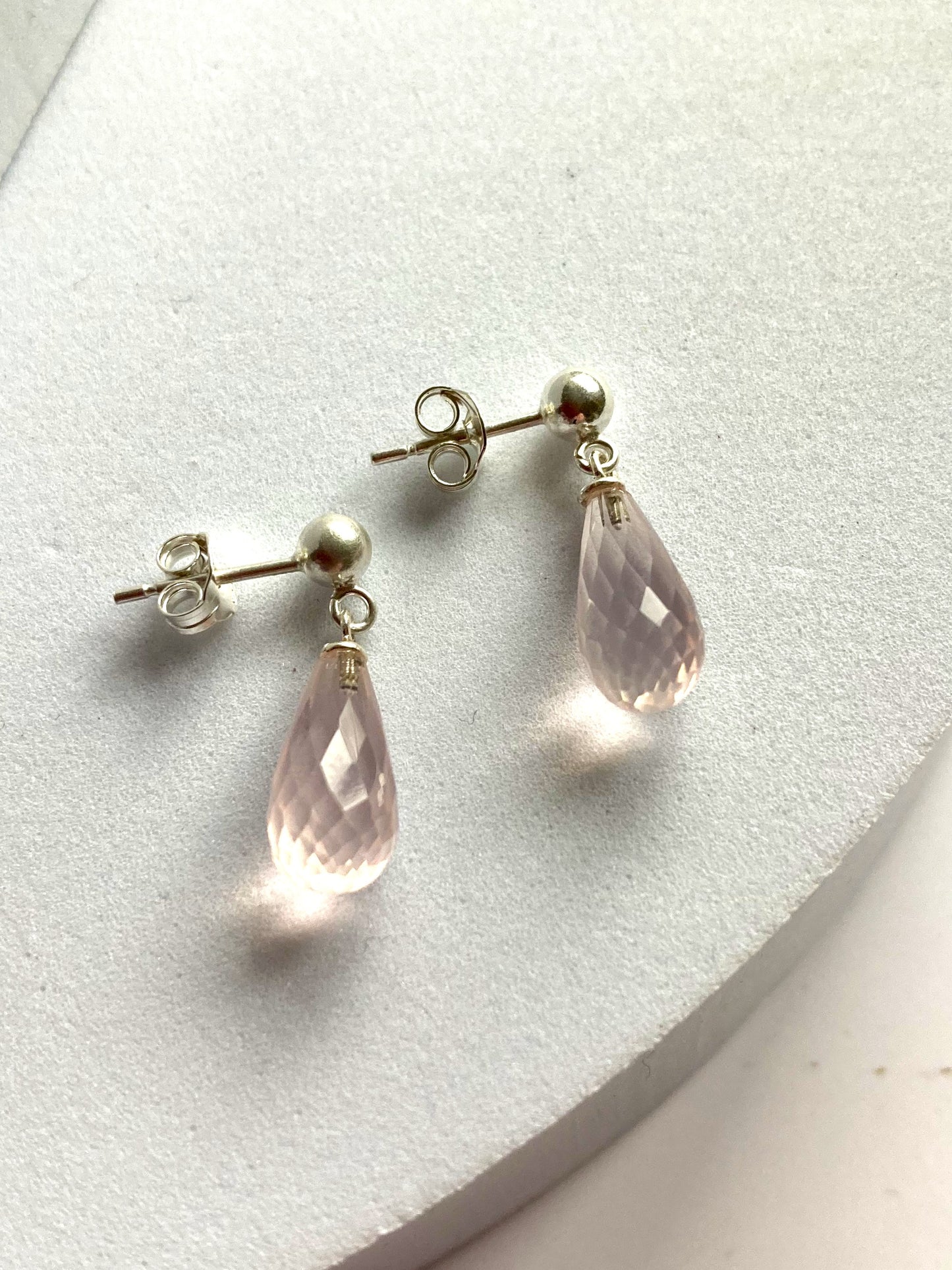 Rose quartz briolette drop earrings on grey background