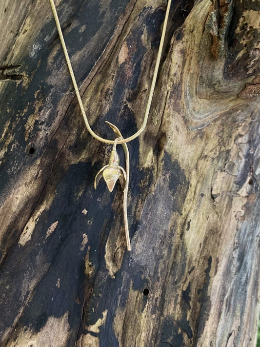 gold snowdrop pendant with wood background