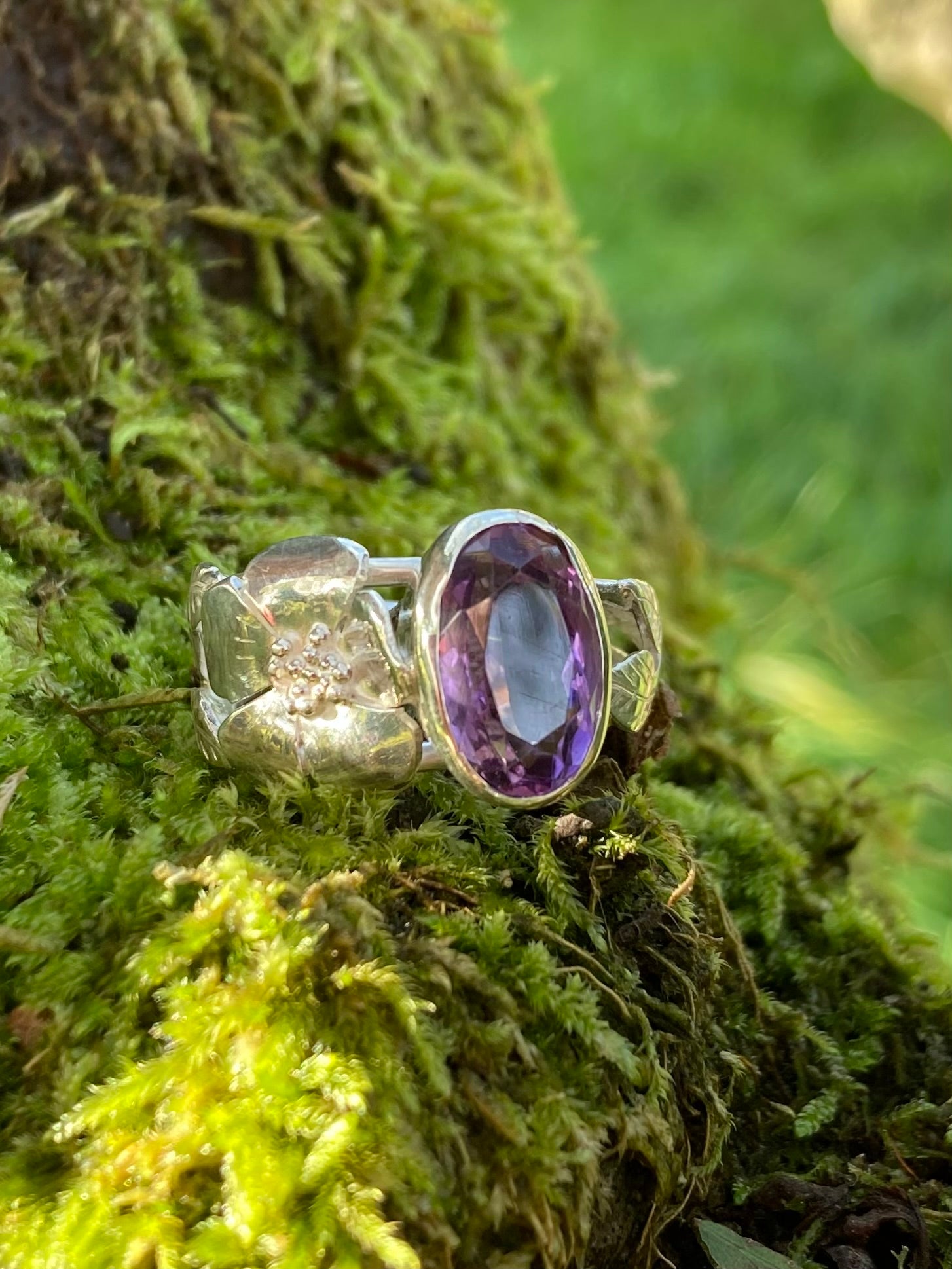oval amethyst and rose silver ring on moss