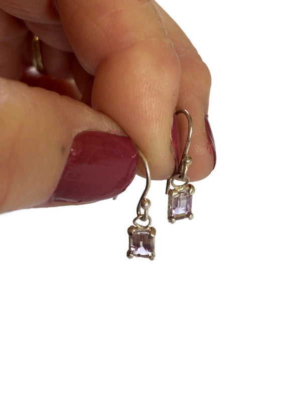 Kim Styles silver earrings with yellow purple ametrine gemstones held by a hand against a white background