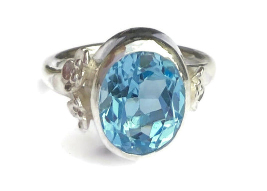 Kim Styles sterling silver floral cocktail ring with an oval blue topaz gemstone on a white background
