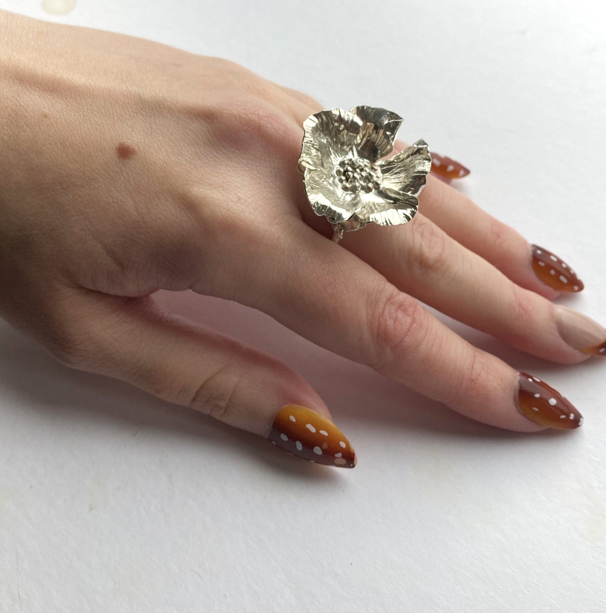 large wrinkled poppy cocktail ring by Kim Styles Jewellery worn on hand, white background
