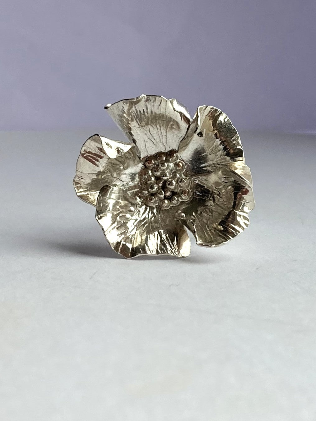 large hand forged flower ring in sterling silver b Kim Styles Jewellery, on grey background