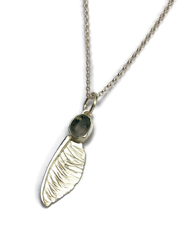 handmade silver sycamore seed pendant by Kim Styles Jewellery set with oval moss agate on white background