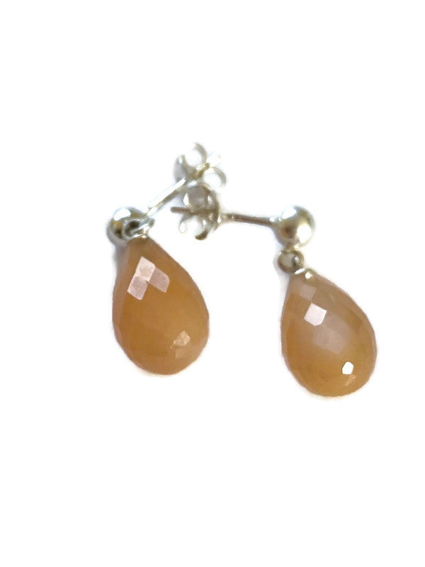 Teardrop-shaped peach moonstone stud earrings on a white background