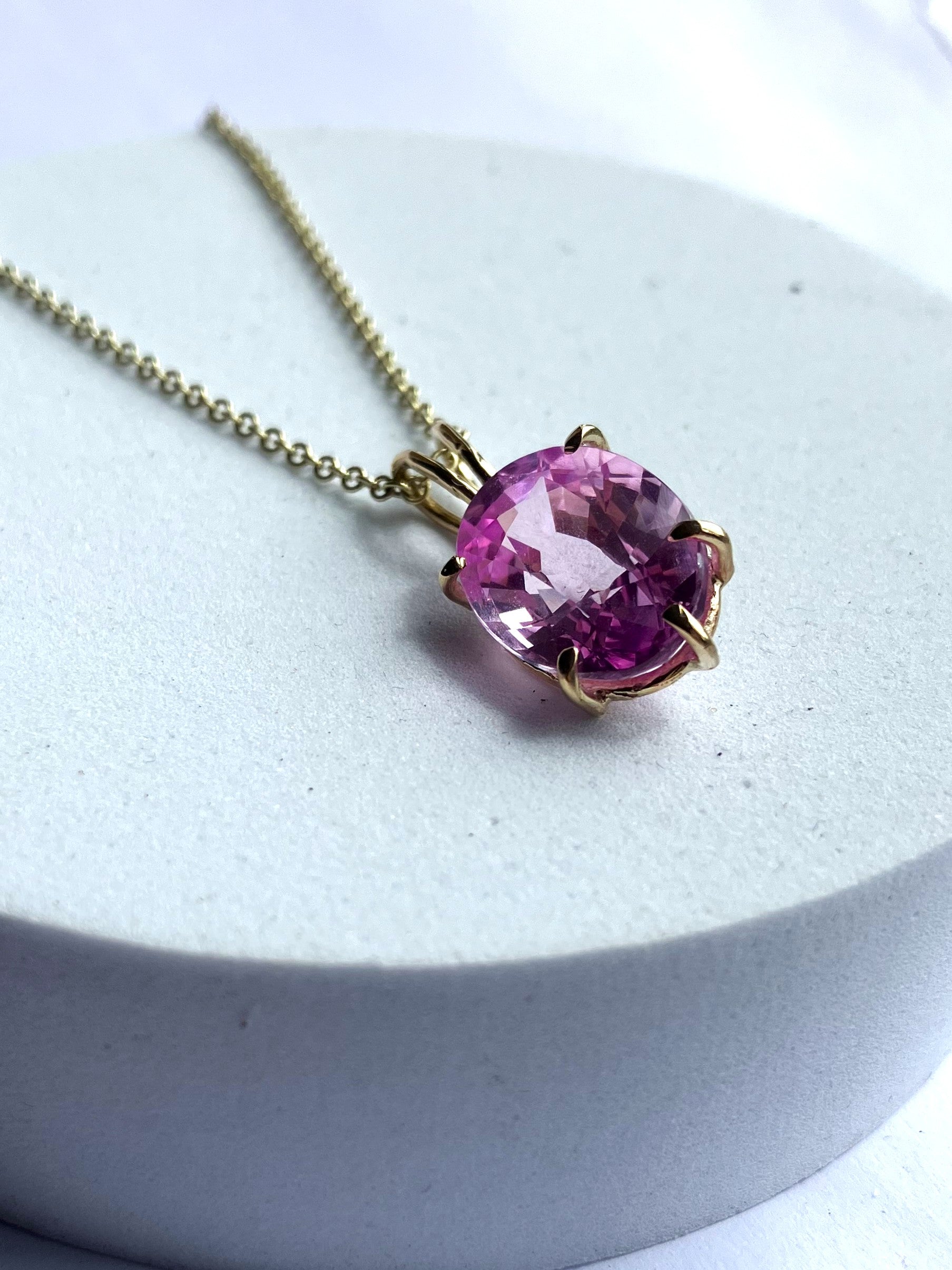 Large oval pink spinel pendant in gold prong setting on 18 inch gold chain, handmade one-of-a-kind gemstone necklace with vibrant 11 carat pink spinel, on white background