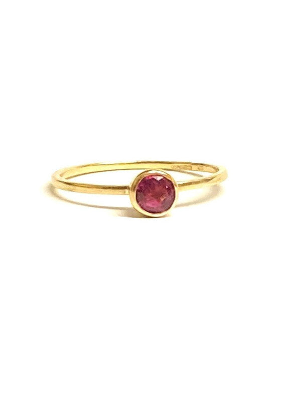 Kim Styles slim gold ring with a red  ruby gemstone on a white background 