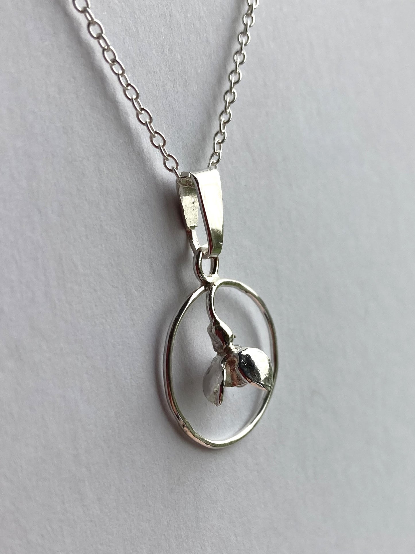3D snowdrop pendant by Kim Styles Jewellery om grey background