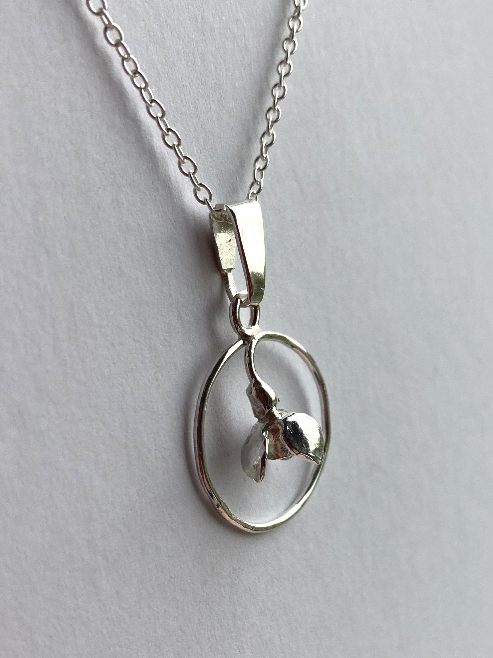 3D snowdrop pendant by Kim Styles Jewellery om grey background