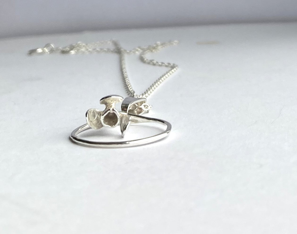 3D floral pendant lying down on grey background