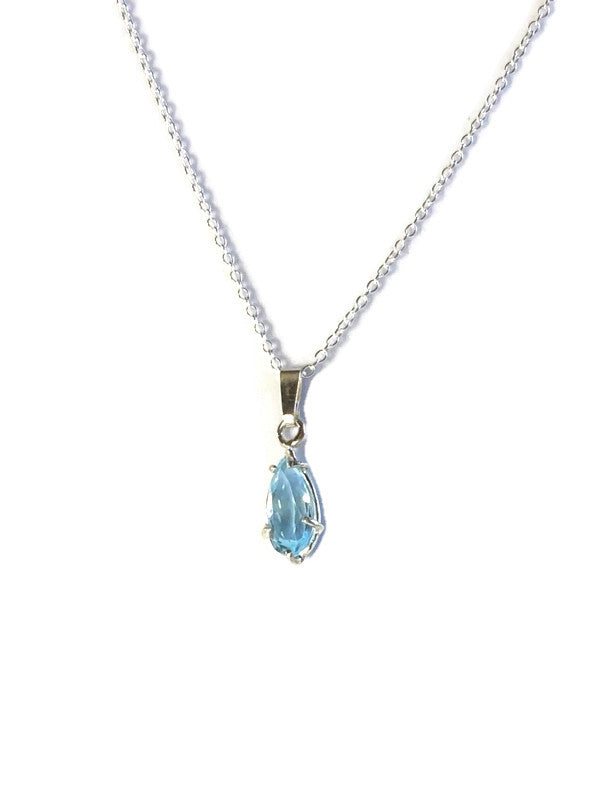 Kim Styles silver necklace with a long pear shape blue topaz pendant on a white background