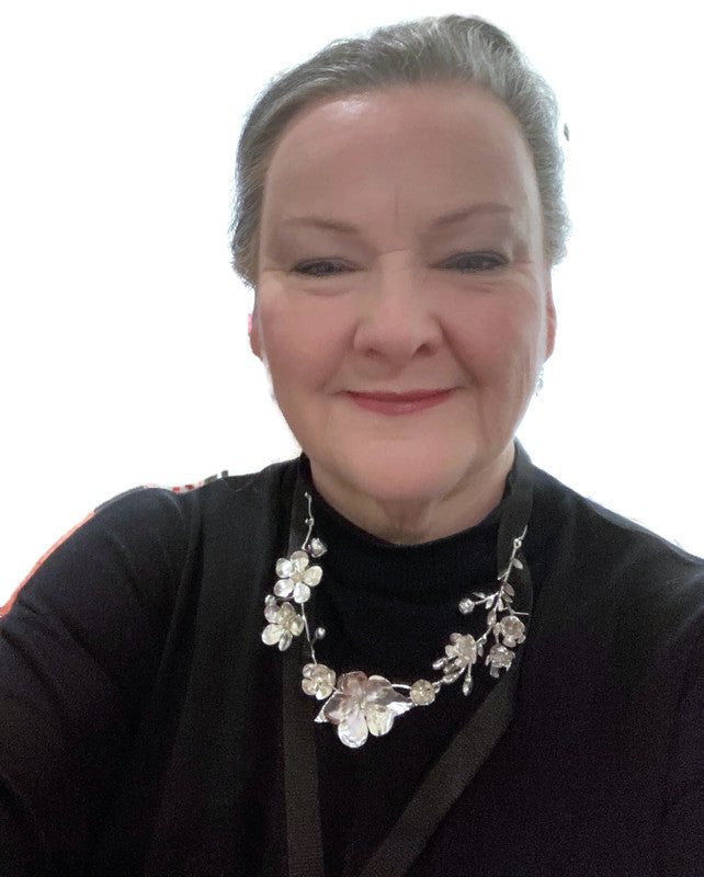 Detailed botanical flower statement necklace worn on models head and neck with cherry blossom, apple blossom and wax flowers in silver