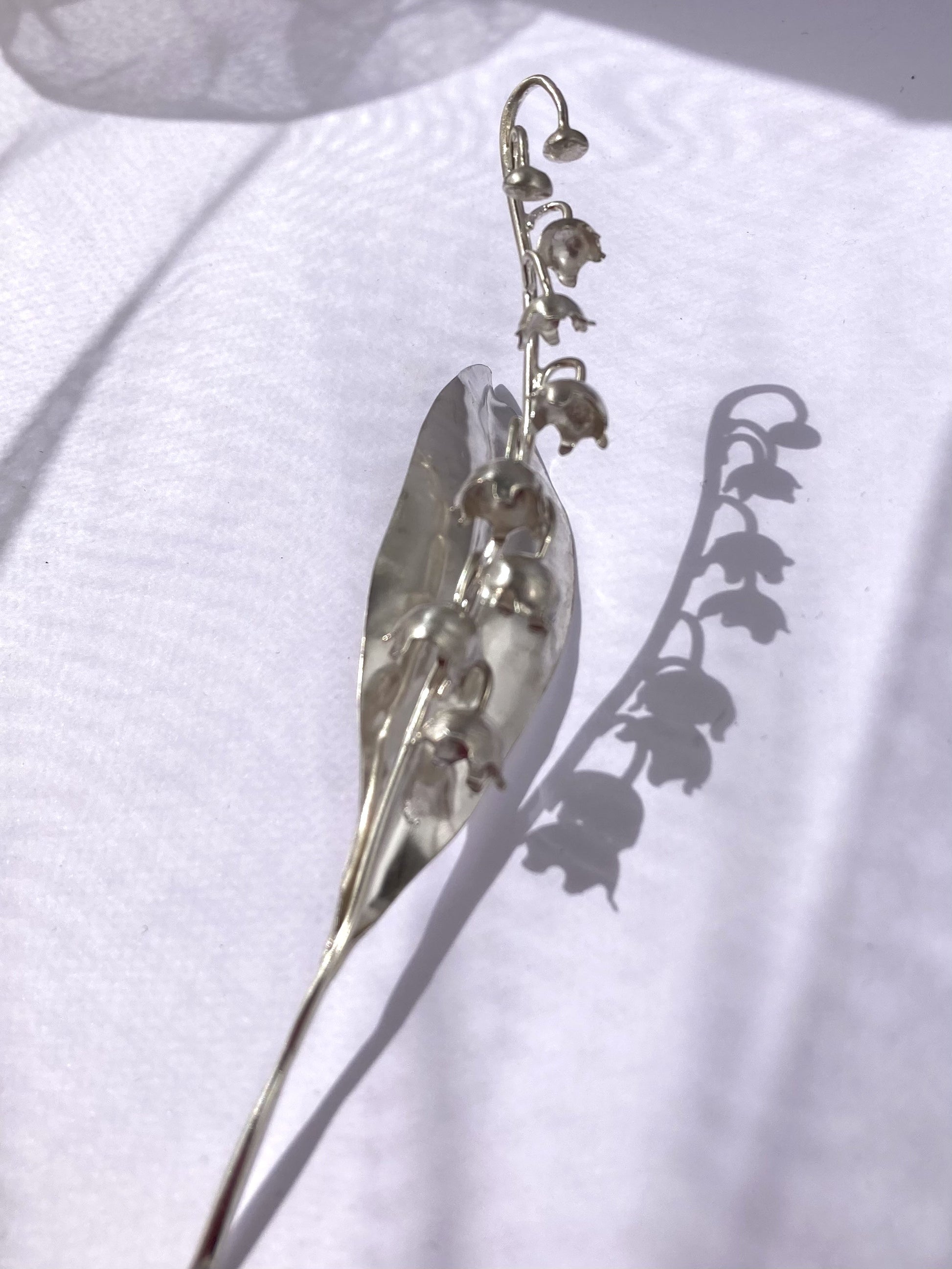 silhouette and shadow of lily of the valley flower in silver