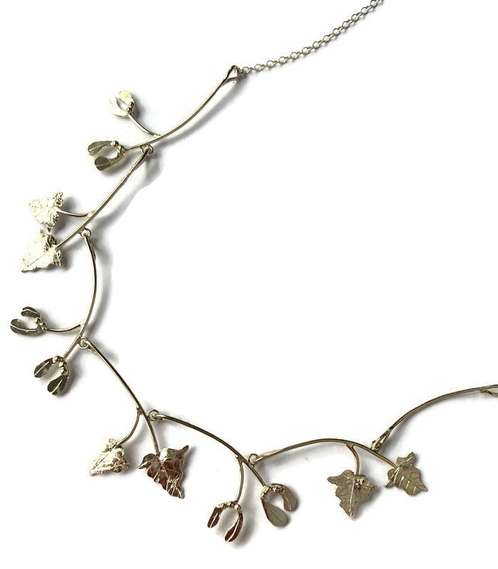silver handmade necklet with mistletoe and vine leaves on white background