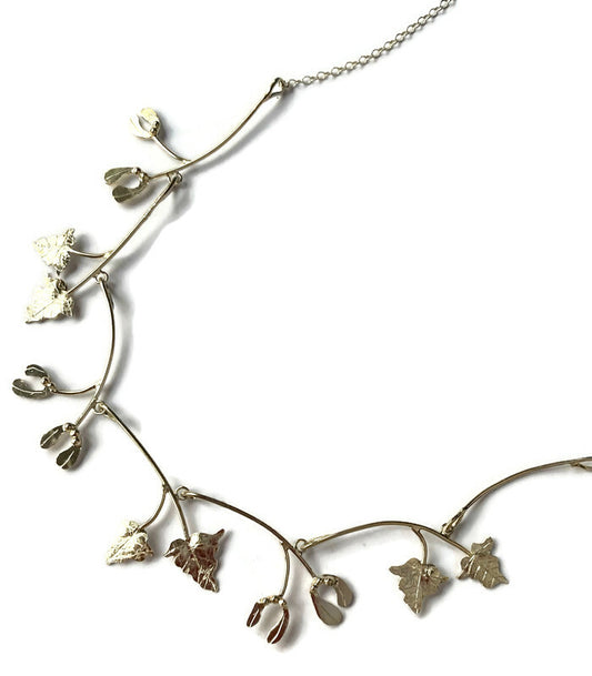 silver handmade necklet with mistletoe and vine leaves on white background