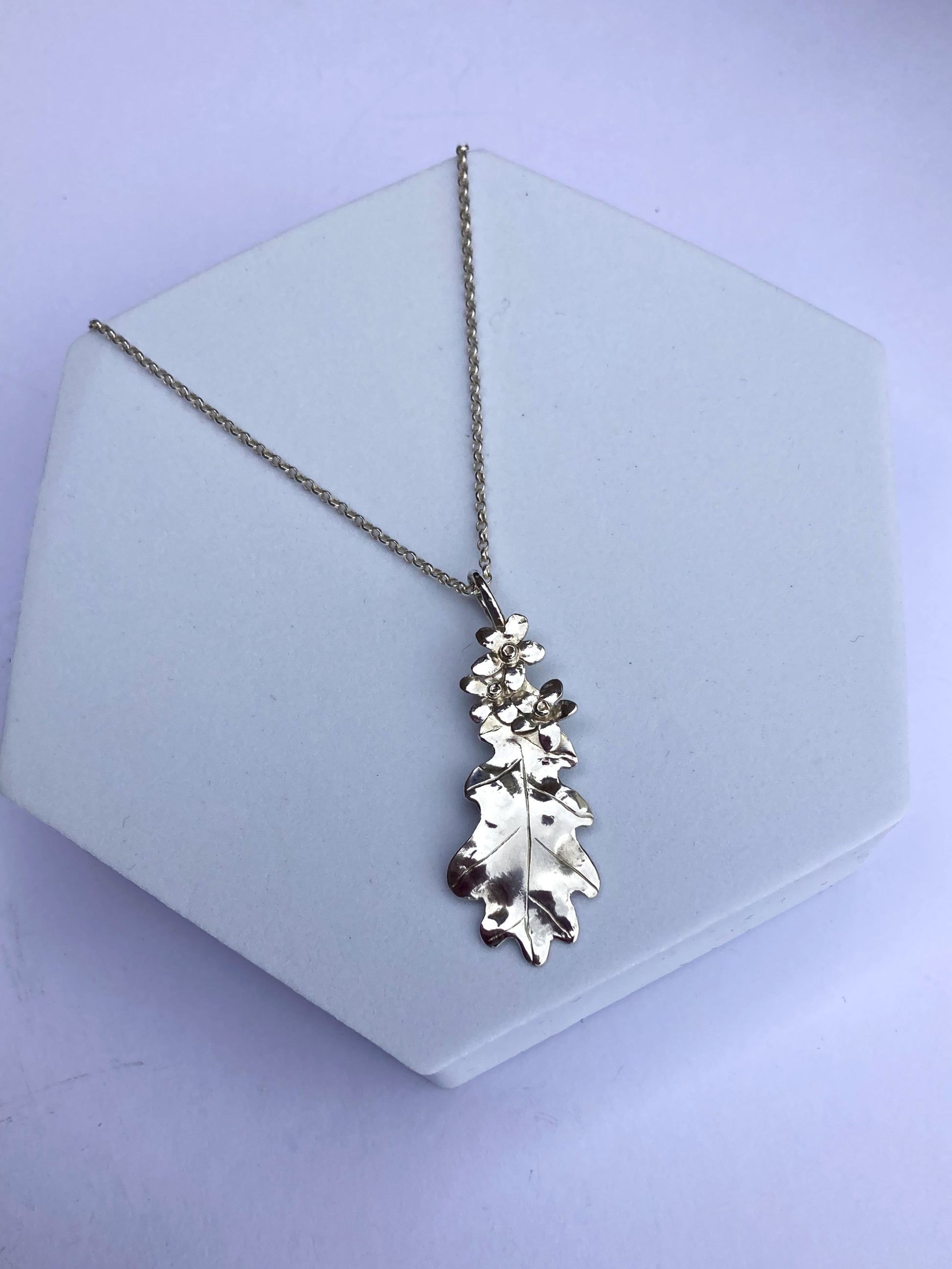 botanical oak leaf and forget-me-not silver pendant on grey hexagon