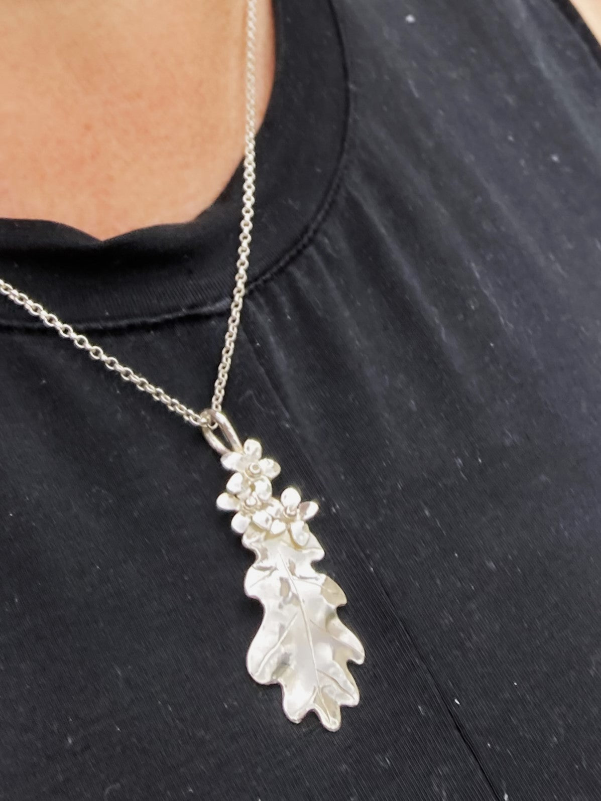 floral oak leaf pendant worn on black t-shirt