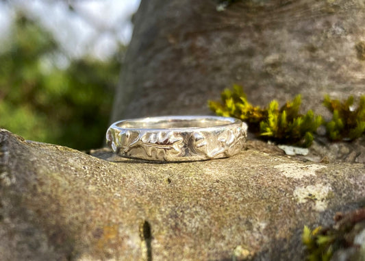 oak and acorn theme wide wedding band on tree branch