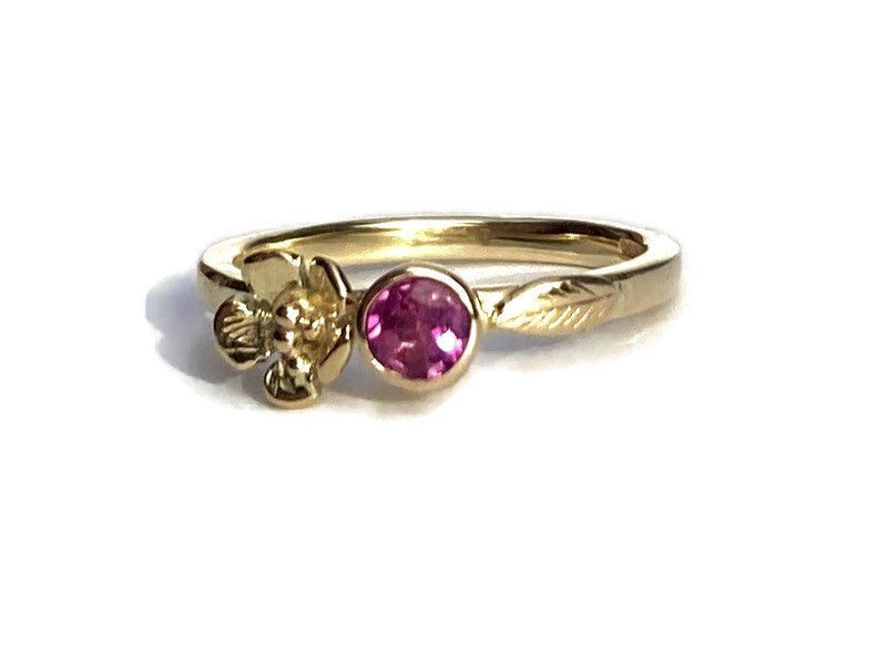 asymmetrical floral solitaire gold engagement ring set with round shocking pink tourmaline, on white background