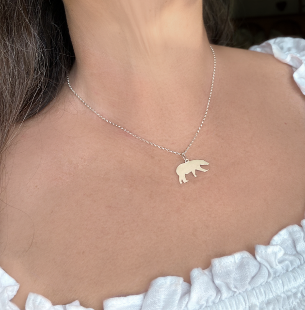 woman's neck with silver polar bear pendant and chain