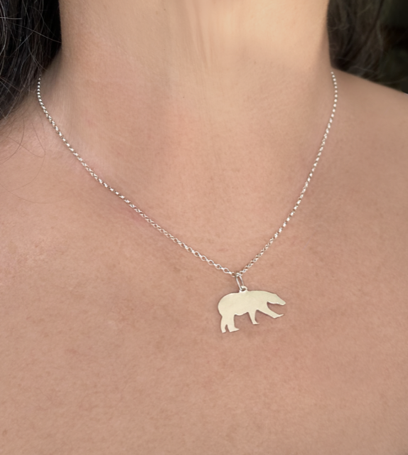 woman wearing silver polar bear pendant on chain
