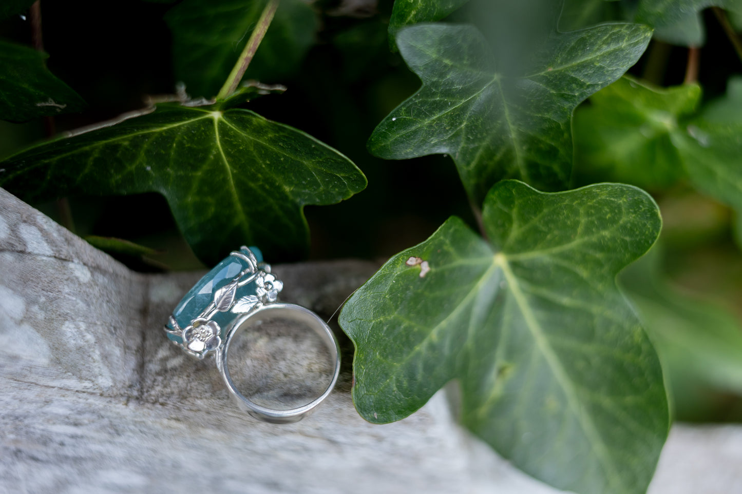 Floral aquamarine silver ring on stone with ivy leaves