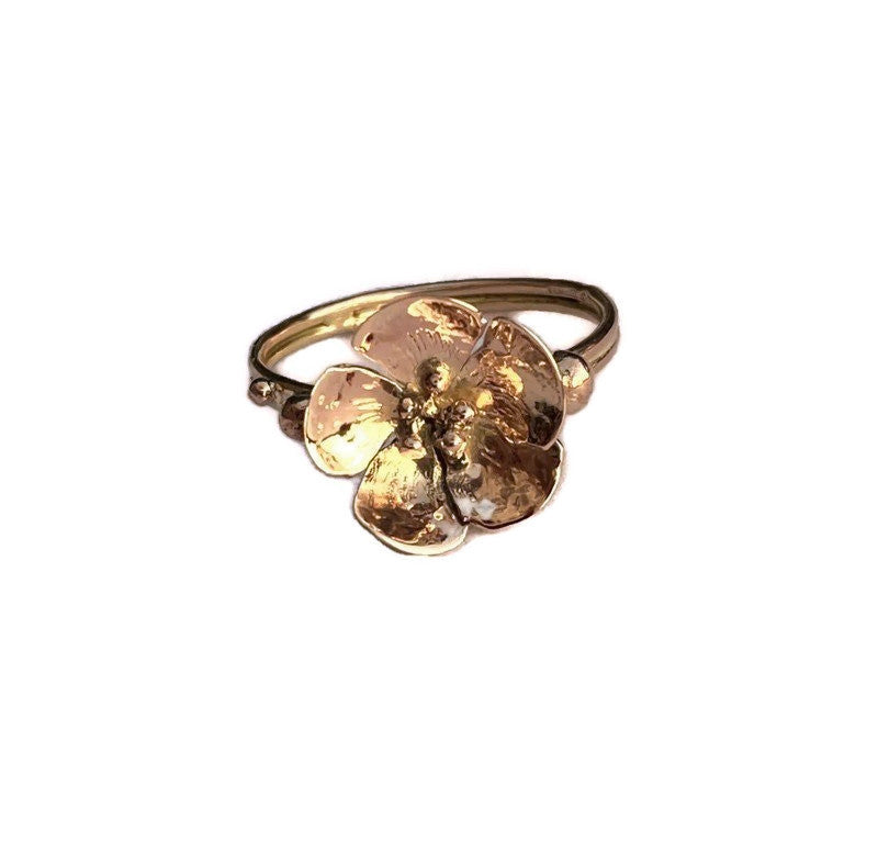 hand forged rose gold flower ring with dual shank, on white background