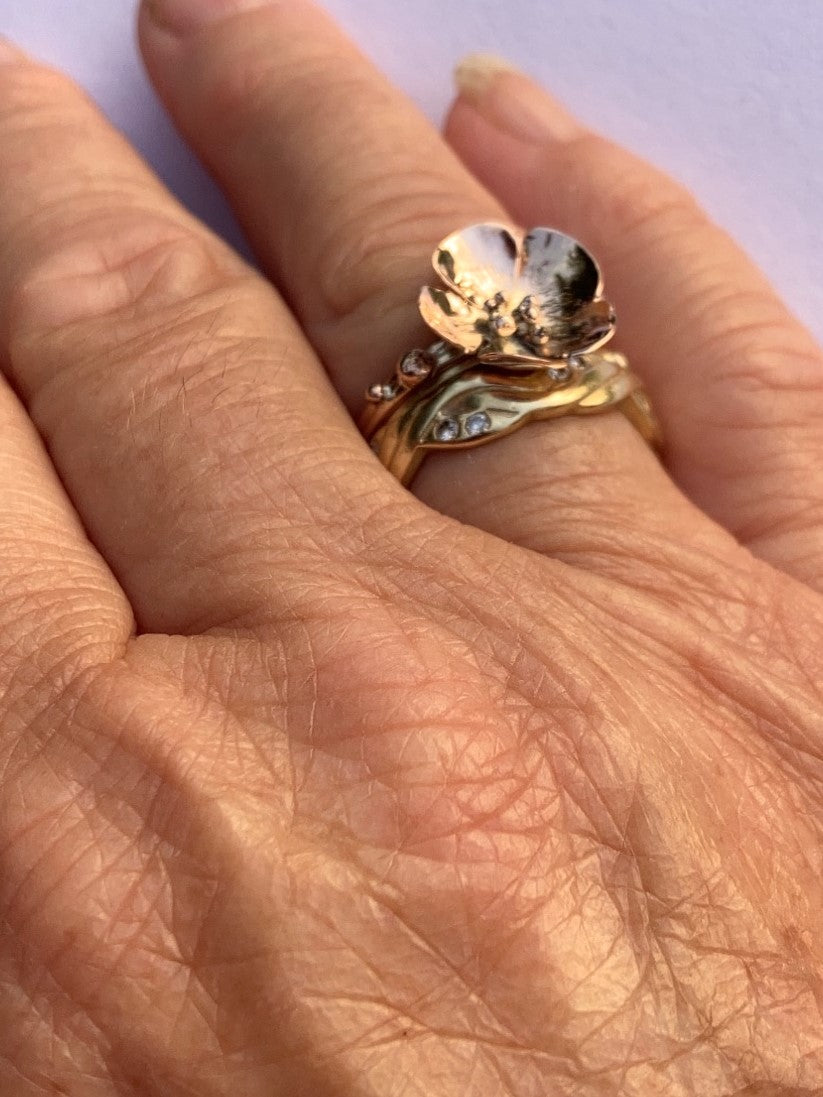 single flower gold ring worn on hand