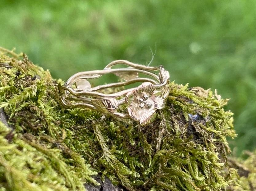 openwork gold ring with leaves and a flower