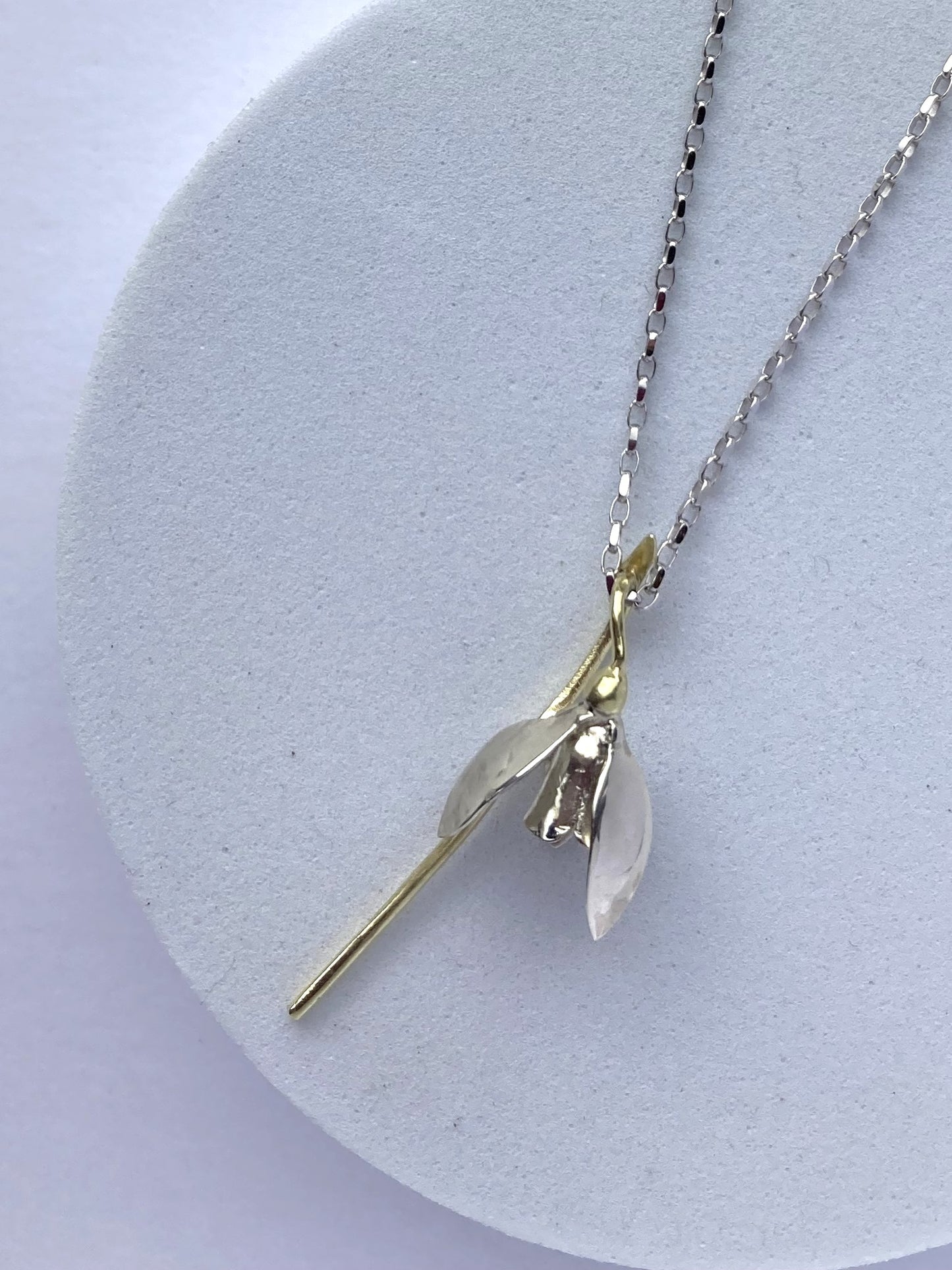 green and white gold handmade snowdrop botanic pendant on grey plinth