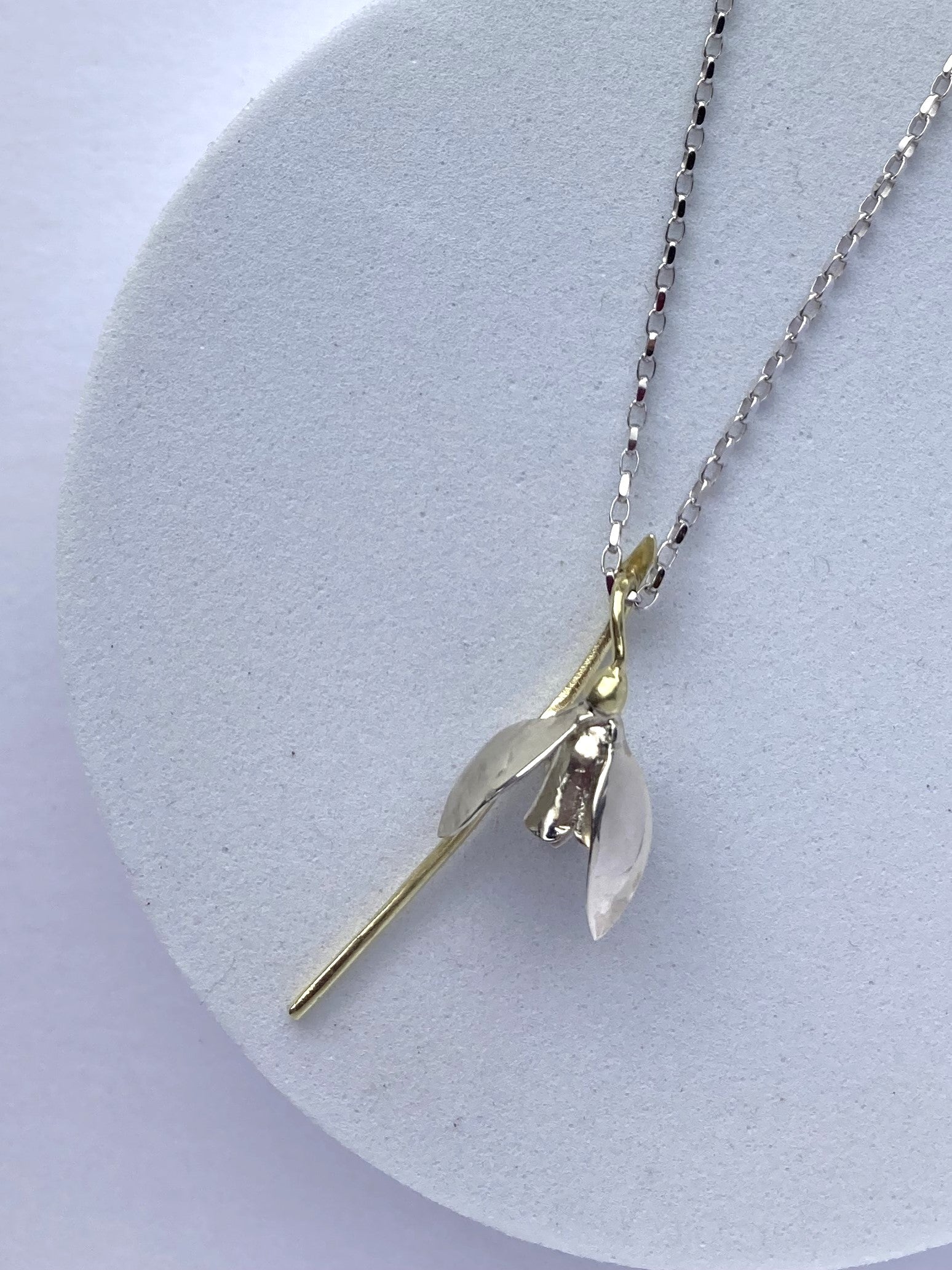 green and white gold handmade snowdrop botanic pendant on grey plinth
