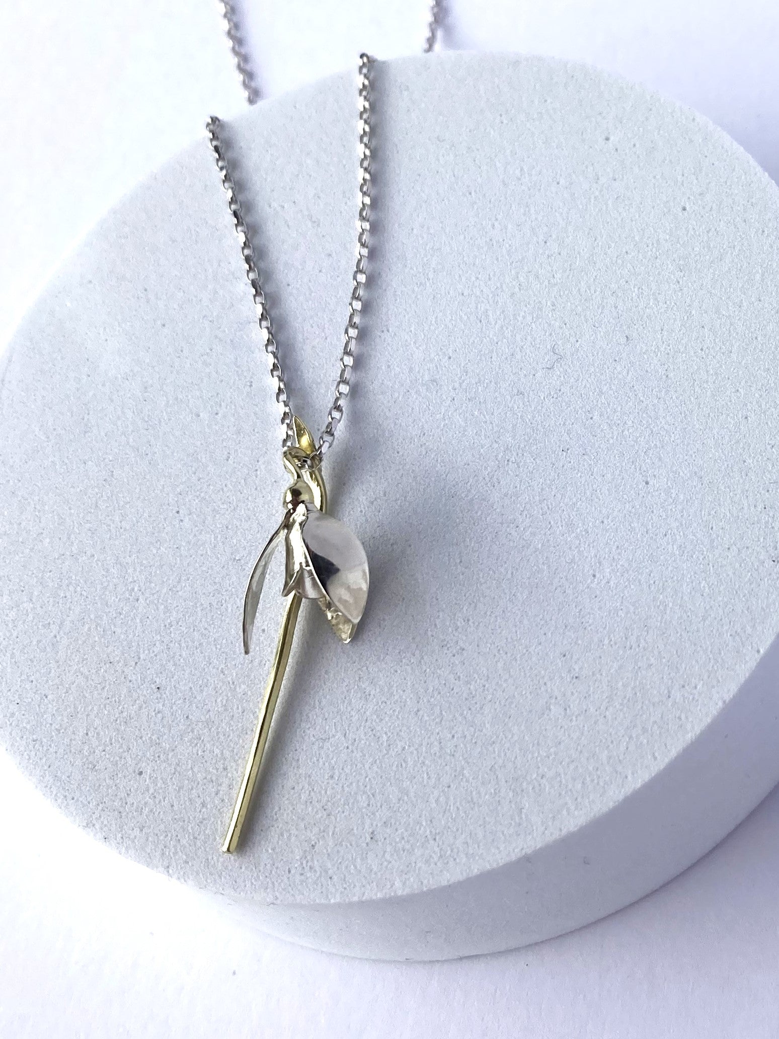 snowdrop gold pendant on grey plinth