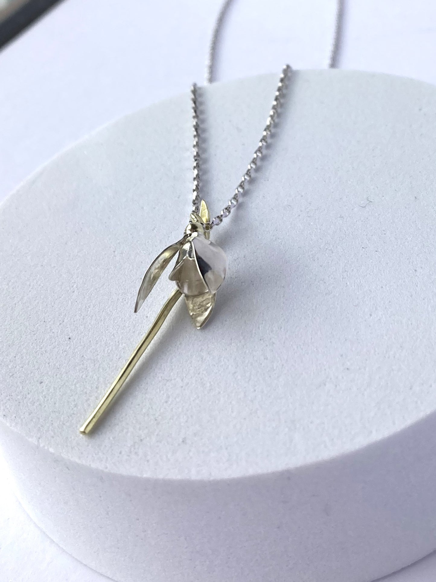 white gold  snowdrop flower necklace on white plinth