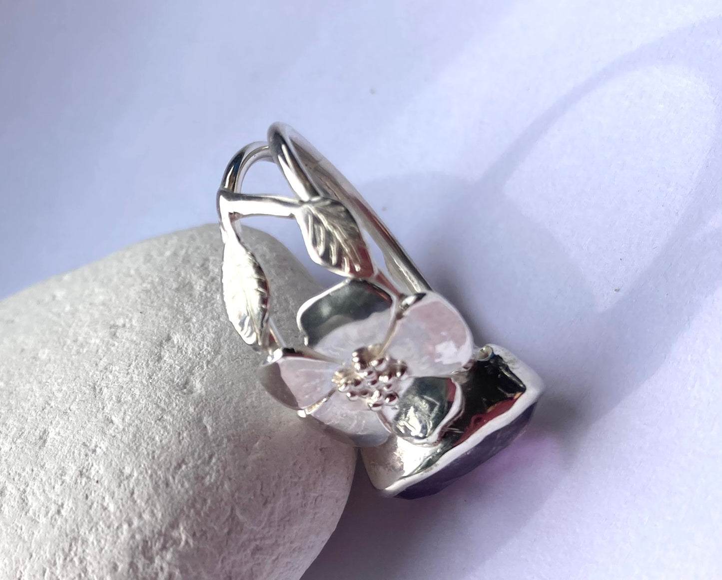 flower and leaves silver ring on white pebble