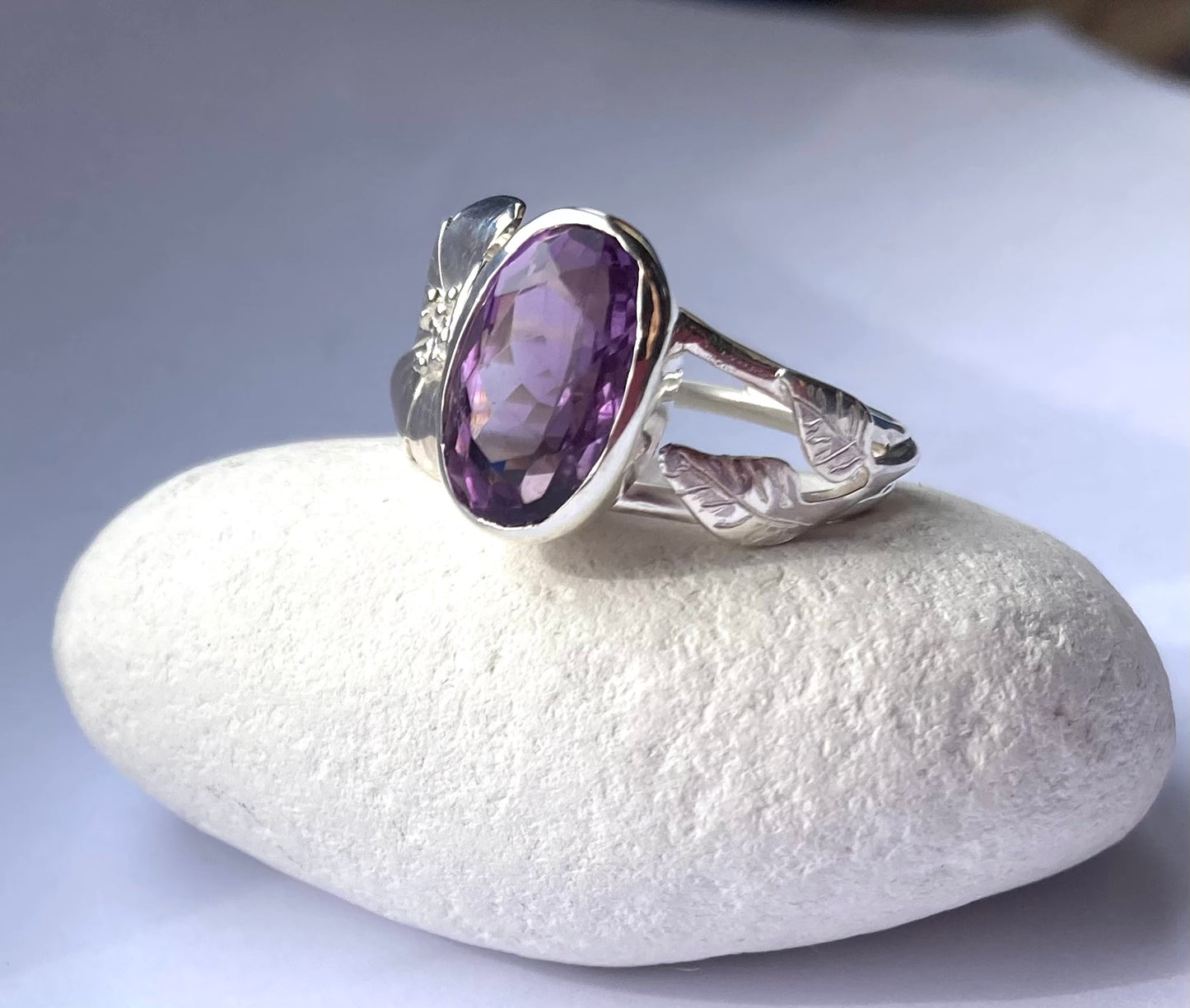 oval amethyst floral ring on white pebble