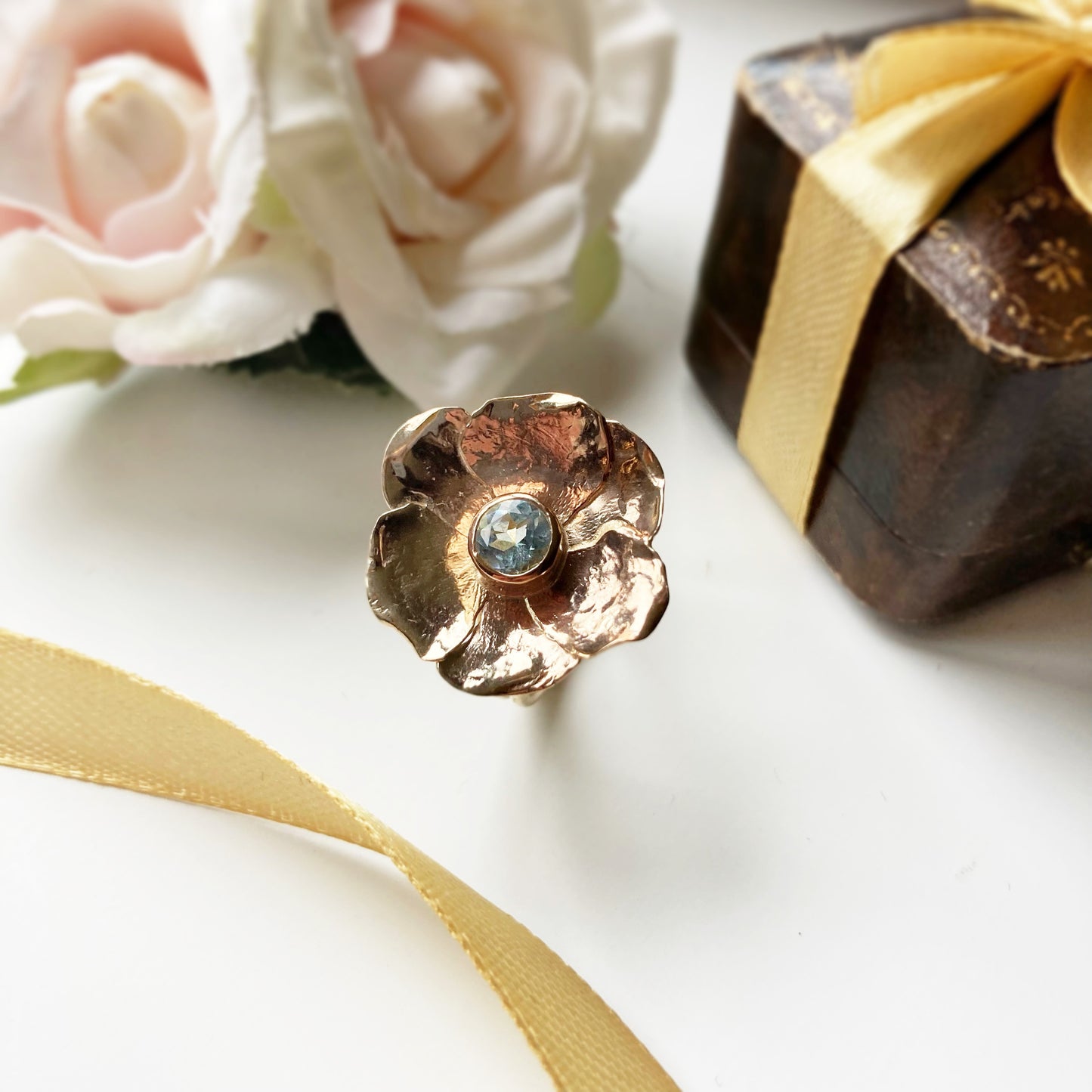 statement yellow gold floral cocktail ring with pale blue central gemstone, with gold ribbons, pale pink flowers and vintage box