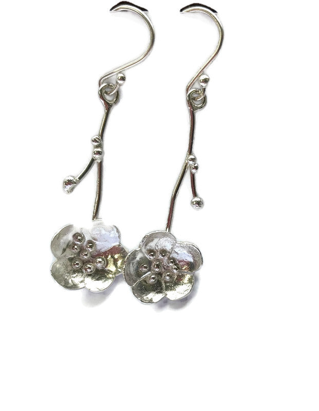 pair of hand forged floral drop earrings, on white background