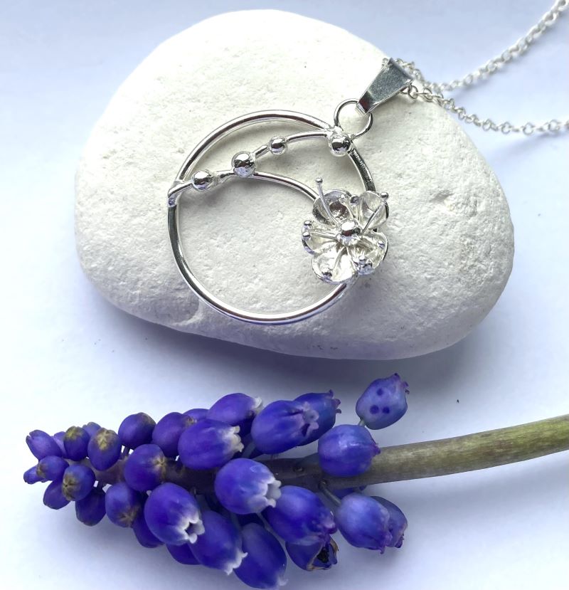 floral circle pendant and chain, on white pebble, with real blue muscari