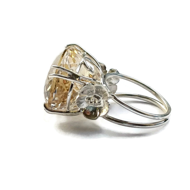 very large yellow gemstone cocktail ring with flower details on white background