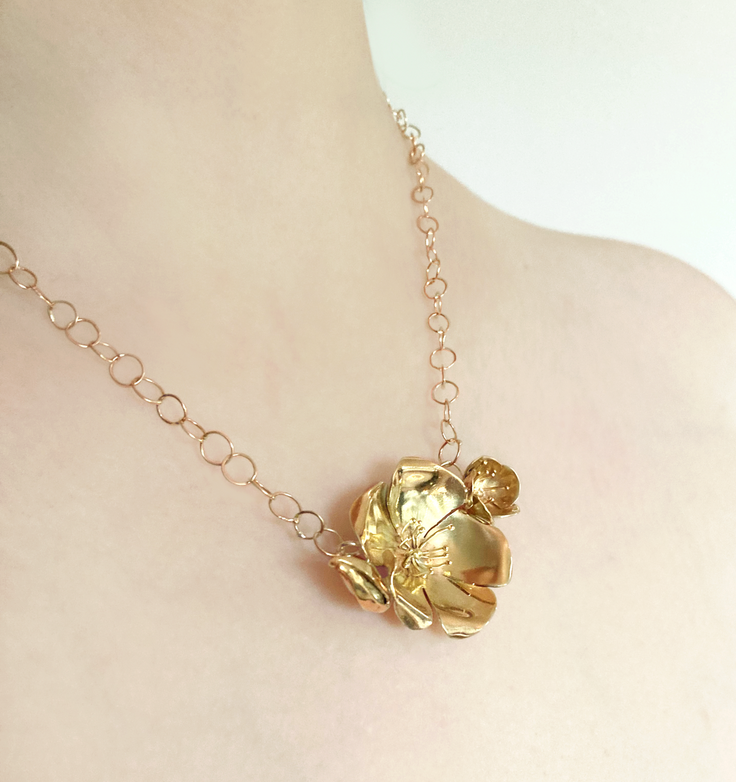 woman's neck wearing statement hand forged solid gold rose necklace and large link chain