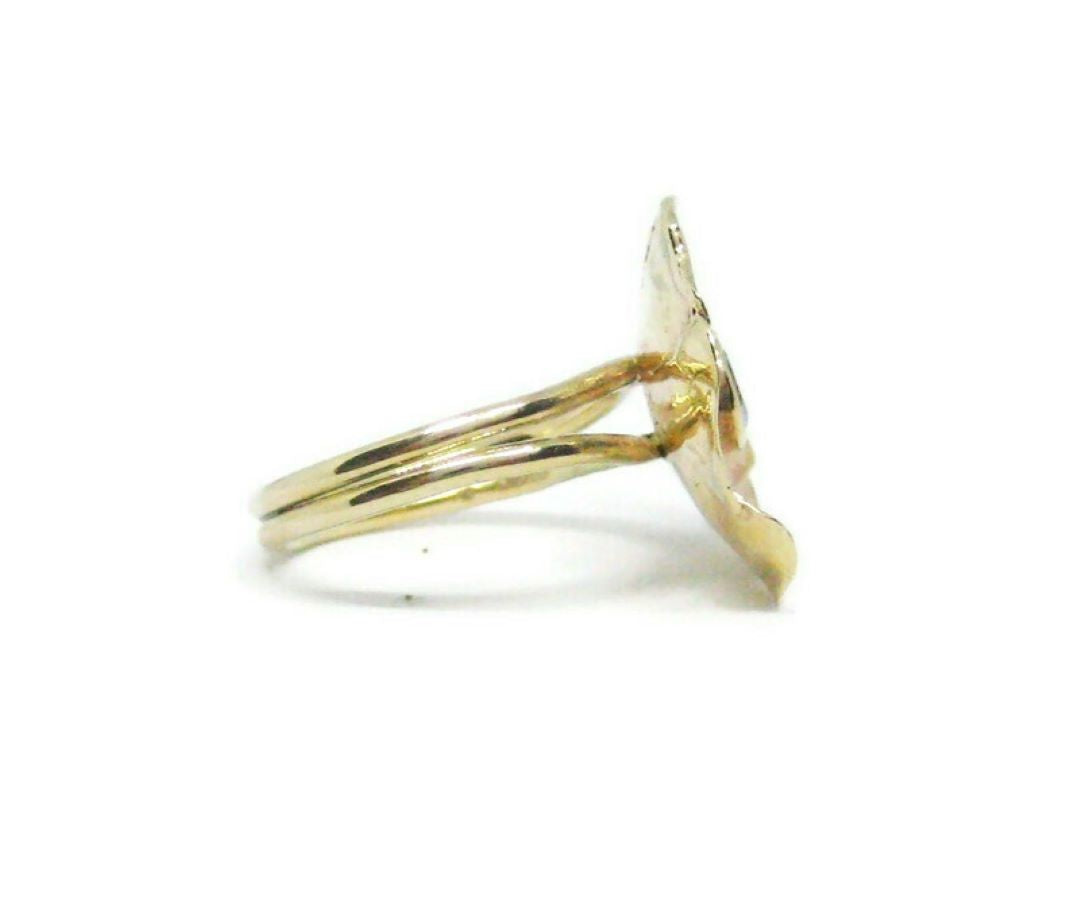 side view of split shank yellow gold flower cocktail ring, on white background