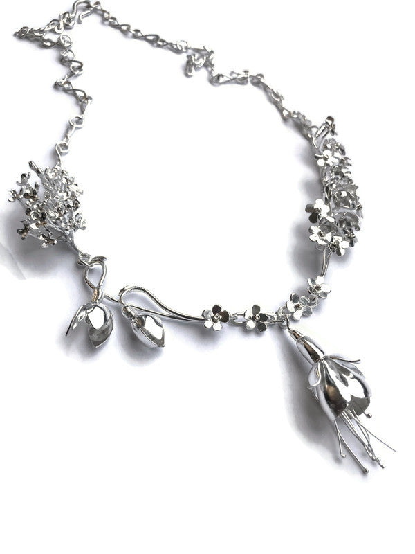 silver statement necklace of handmade flowers on  white background