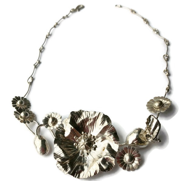 hammered texture botanical poppy and daisy statement necklace on wite background 