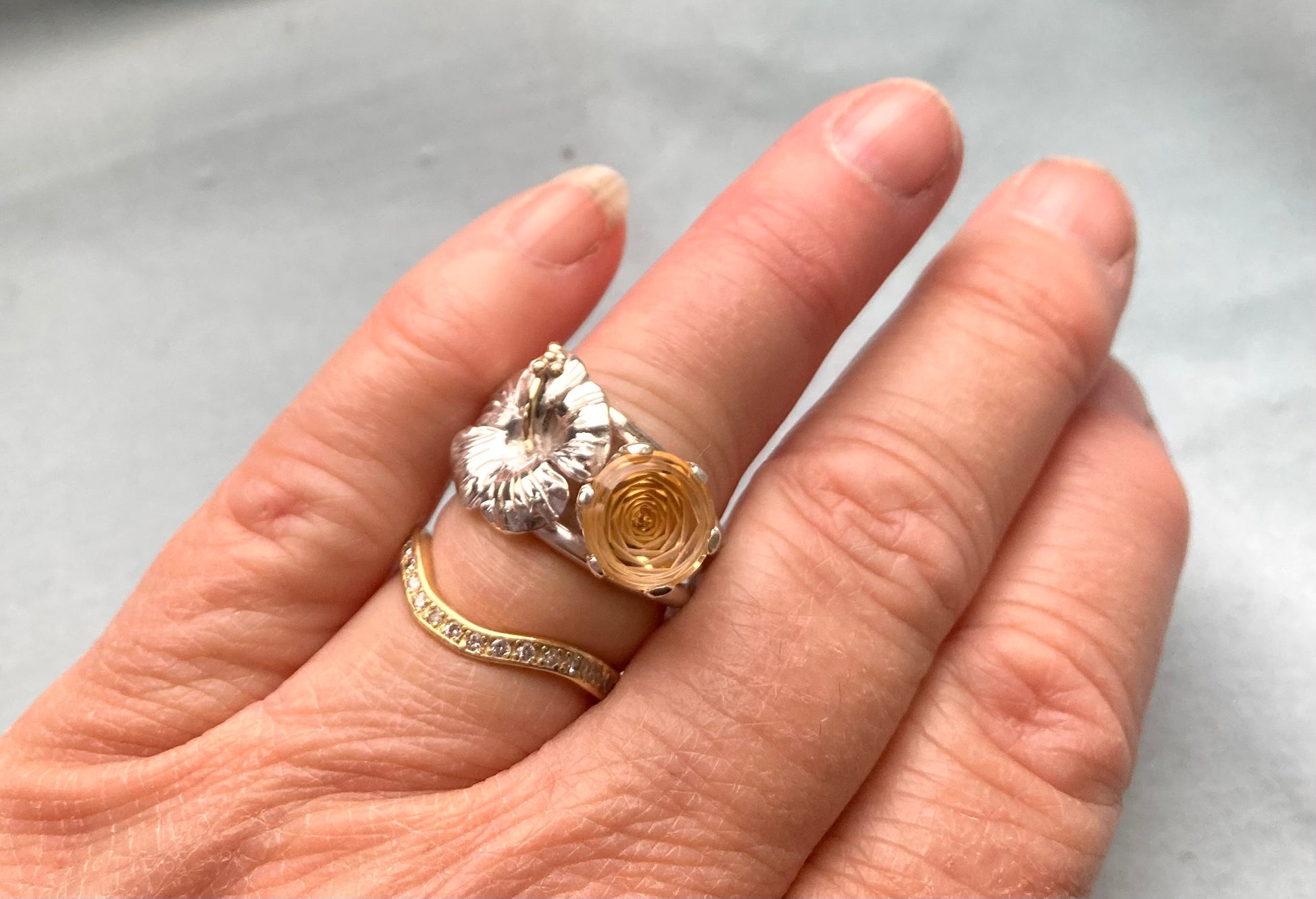 pretty floral cocktail ring with yellow stone and large hibiscus flower, worn on hand
