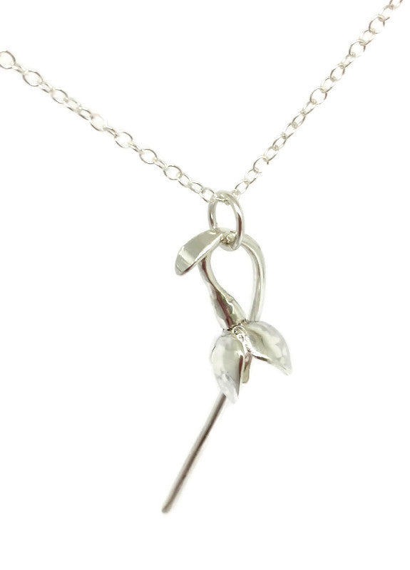 single silver snowdrop flower hanging from chain, on white background